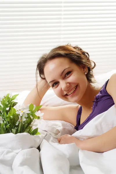 Ganska kaukasisk kvinna ligger i en säng av blommor — Stockfoto