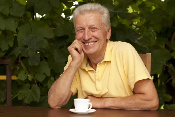 Amusing older man sitting on the veranda — Stock Photo, Image