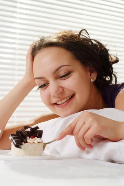 美しい女性ケーキのベッドで横になっています。 — ストック写真