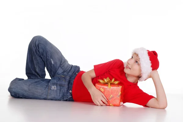 Kid in Kerstman hoed met cadeau — Stockfoto