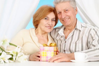 Good-lloking older couple resting in the bedroom clipart