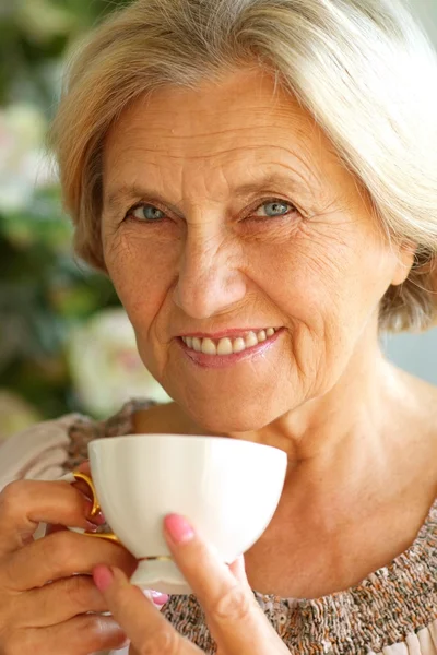 Old woman drinking tea — Stock Photo, Image