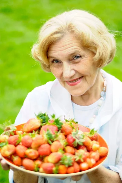 Bella vecchia donna con le fragole — Foto Stock