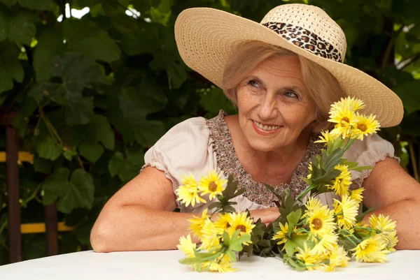 Beauteous older woman sitting on the veranda — Stock Photo, Image