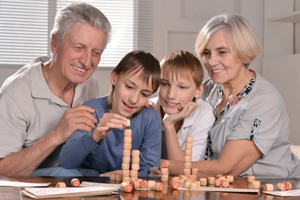 Два мальчика, бабушка и дедушка играют в лото — стоковое фото