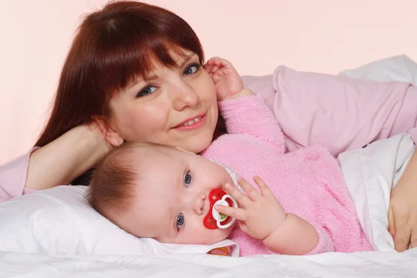 Une heureuse momie caucasienne avec sa fille couchée au lit — Photo