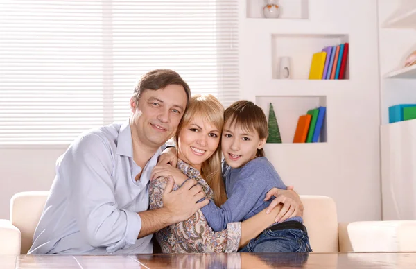 Famiglia seduta sul divano di casa — Foto Stock