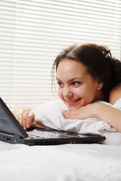 Belle femme caucasienne couchée dans un lit d'ordinateur — Photo