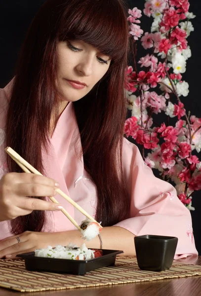 Beautiful girl eating sushi — Stock Photo, Image