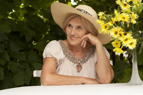 Schoone oudere vrouw zitten op de veranda — Stockfoto