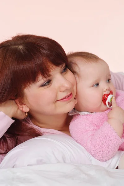 Eine glückliche kaukasische Mutter mit ihrer Tochter im Bett liegend — Stockfoto