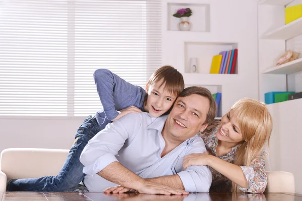 Famiglia seduta sul divano di casa — Foto Stock