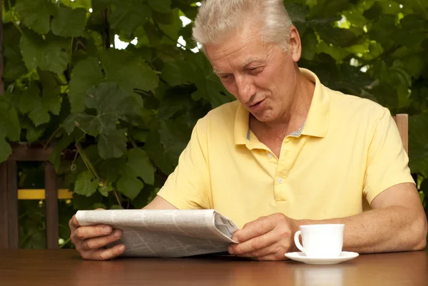Lezing oudere man zit op de veranda — Stockfoto