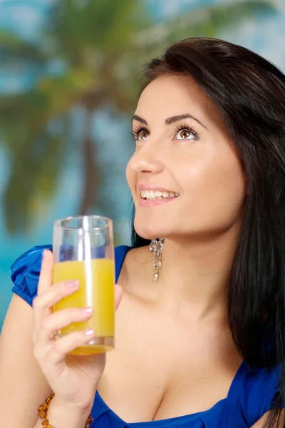 Mulher jovem com suco em um azul — Fotografia de Stock