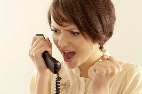 Mujer joven enojada con un teléfono — Foto de Stock