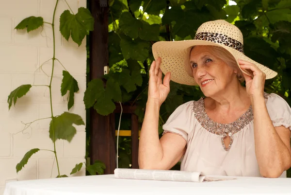 Mujer mayor de miel sentada en la terraza —  Fotos de Stock
