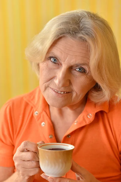 Donna che beve tè sul giallo — Foto Stock