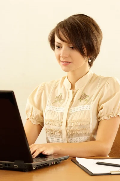 Girl with a laptop on a beige — Stock Photo, Image