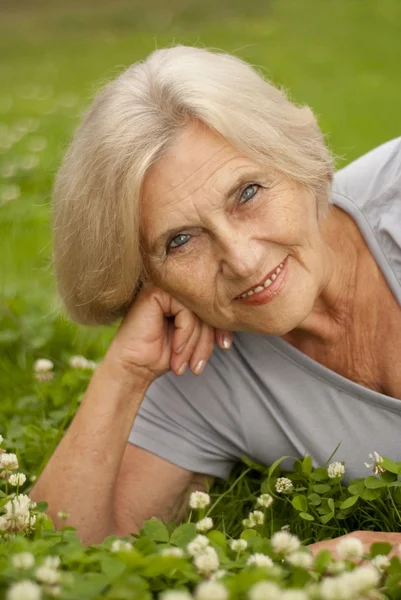 Pretty old woman in the middle of the lawn — Stock Photo, Image
