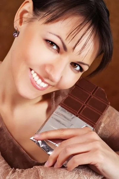 Brunette eats chocolate — Stock Photo, Image