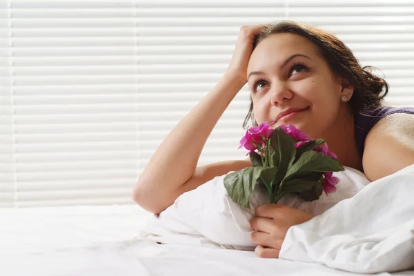 Güzel bir kadın çiçek yatakta yatan — Stok fotoğraf