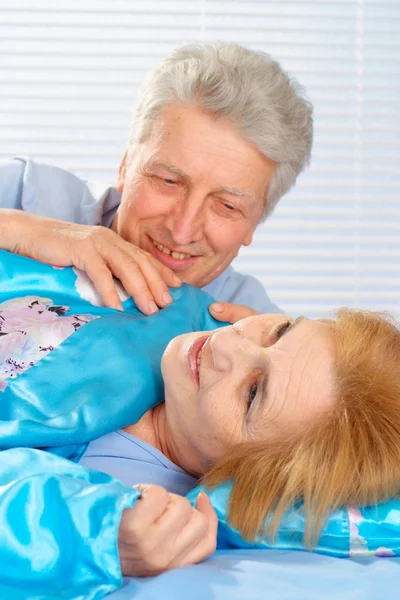 Angenehmes älteres Paar, das sich im Schlafzimmer ausruht — Stockfoto