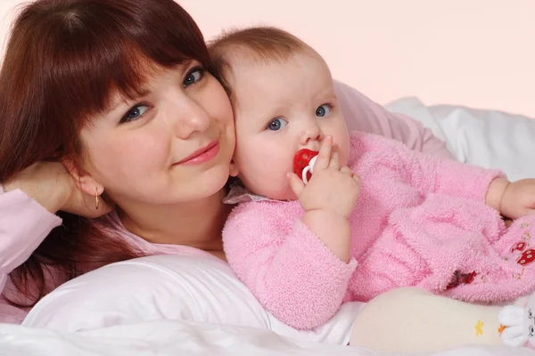 Eine glückliche kaukasische Mutter mit ihrer Tochter, die im Bett liegt — Stockfoto