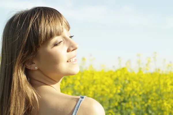 Beauteous young girl in the middle of yellow flowers — Stock Photo, Image