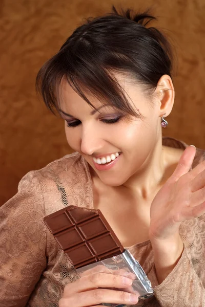 Brunette eats chocolate — Stock Photo, Image