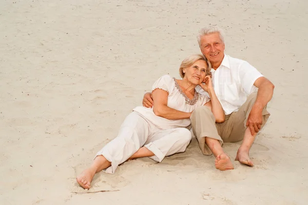 Beautiful elderly couple enjoy the sea breeze — Stock Photo, Image