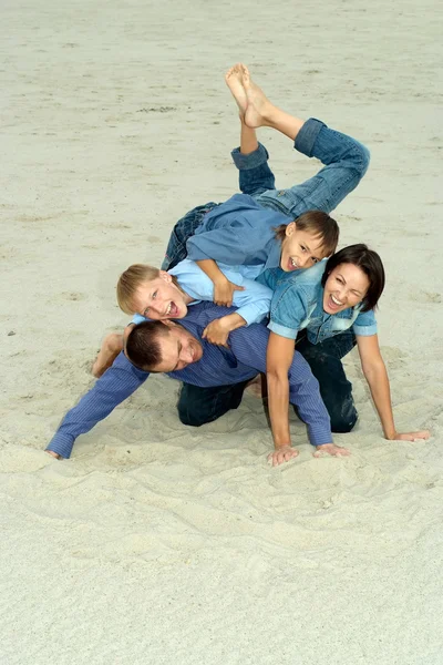 Famiglia in blu sdraiata sulla sabbia — Foto Stock