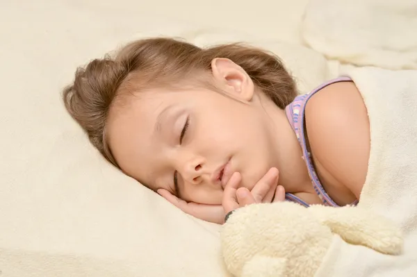 Kleines Mädchen schläft in ihrem Bett — Stockfoto