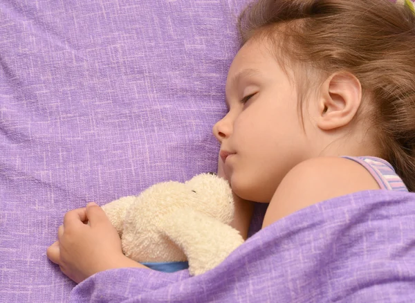 Klein meisje slapen in haar bed — Stockfoto