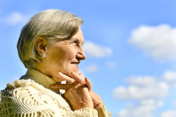 Ευτυχής ηλικιωμένη γυναίκα που παρουσιάζουν ενάντια στον ουρανό — Φωτογραφία Αρχείου