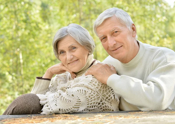 Elderly couple at table in forest — Stock Photo, Image