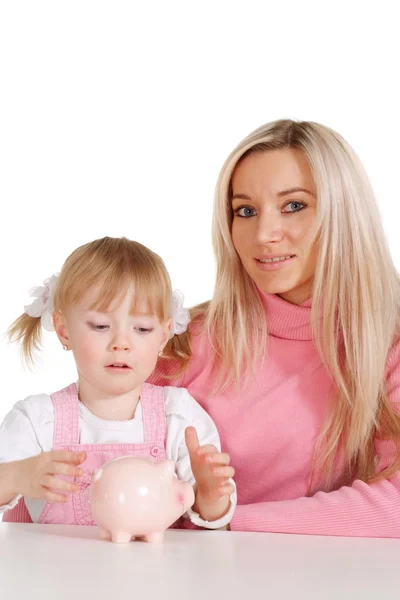 Een mooie Kaukasische mama met haar dochter met moneybox — Stockfoto