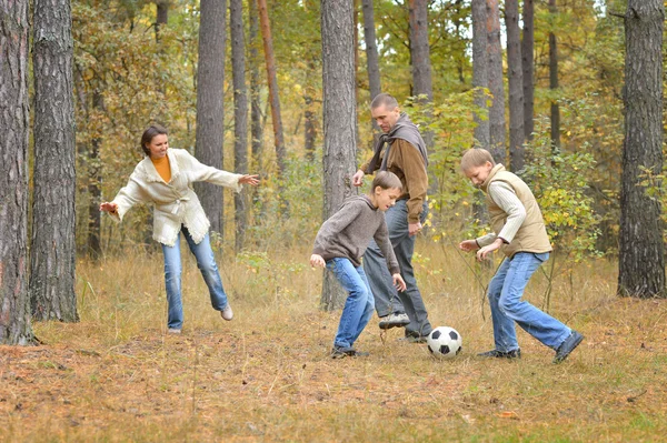 Happy famille jouer football forêt — Photo