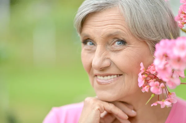 Kvinna med rosa blomma — Stockfoto