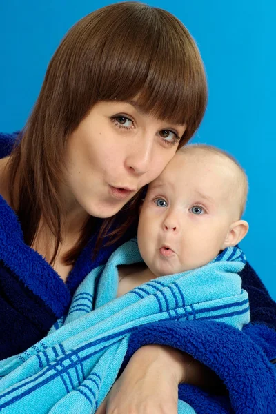 妈妈抱着她的宝宝在一个蓝色 — 图库照片