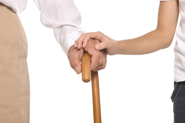 Young and old hands on cane — Stock Photo, Image