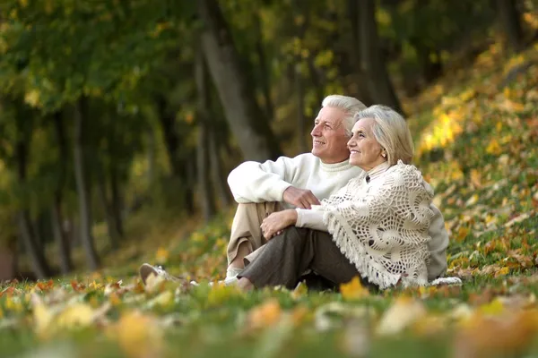 Ancianos sentados en el parque de otoño — Foto de Stock