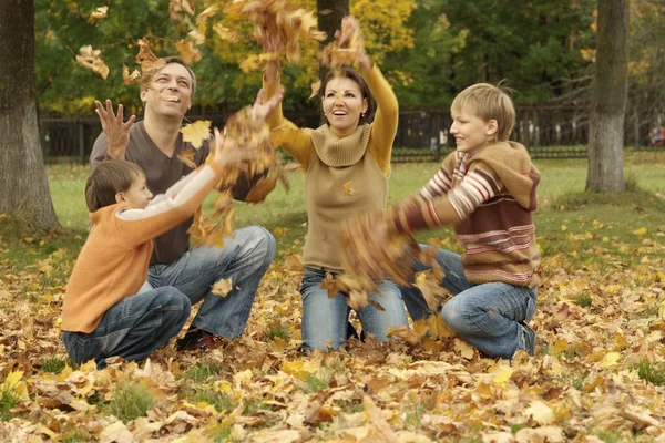 Familia tirar hojas de otoño — Foto de Stock