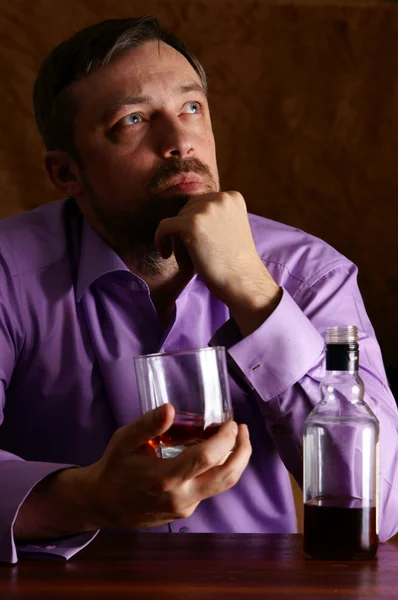 Человек и виски за столом — стоковое фото