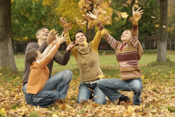 Prachtige familie gooien Herfstbladeren — Stockfoto