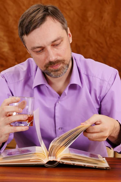 Homem bonito com leitura de uísque — Fotografia de Stock