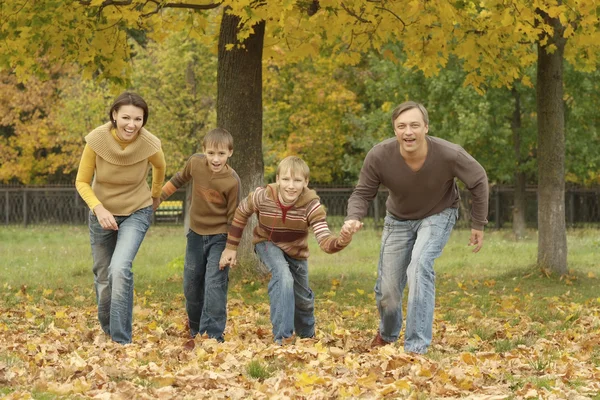 Familjen driver i höst park — Stockfoto