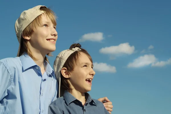 Boys in a caps under a blue sky — Stock Photo, Image
