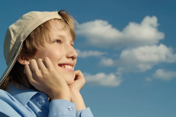 Un hermoso chico caucásico en una gorra se sienta — Foto de Stock