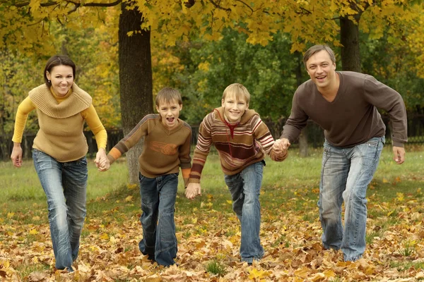 Οικογένεια που τρέχει στο πάρκο φθινόπωρο — Φωτογραφία Αρχείου