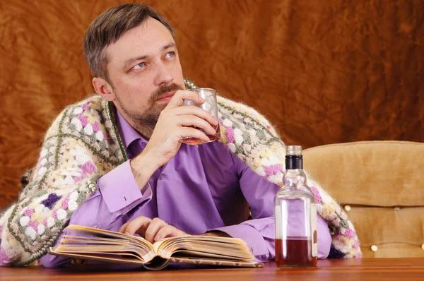 Uomo beve whisky e lettura — Foto Stock